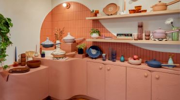 Pans and kitchenware stacked on a coral counter.