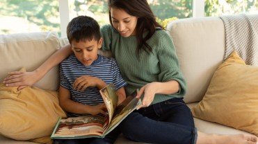 A mother and child reading a book.